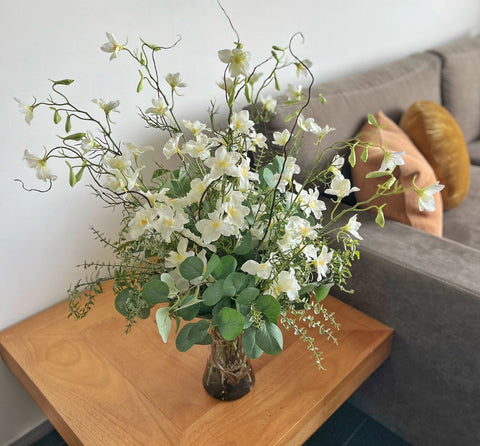 Arreglo Floral con Delphiniums Artificiales en Tonos Blancos en Cilindro de Vidrio con Agua Acrílica