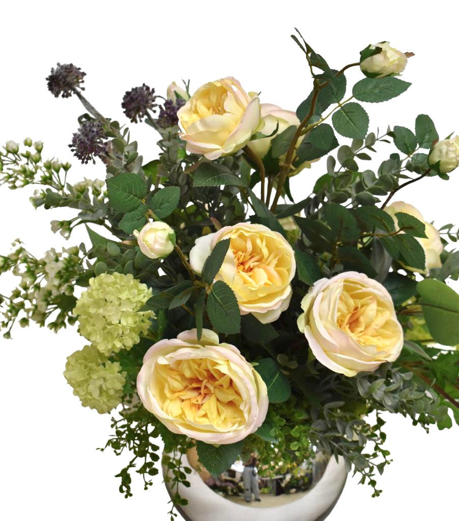 Centro de Mesa con Rosas en Tonos Amarillos y Follajes Artificiales en Base de Vidrio Tipo Espejo.