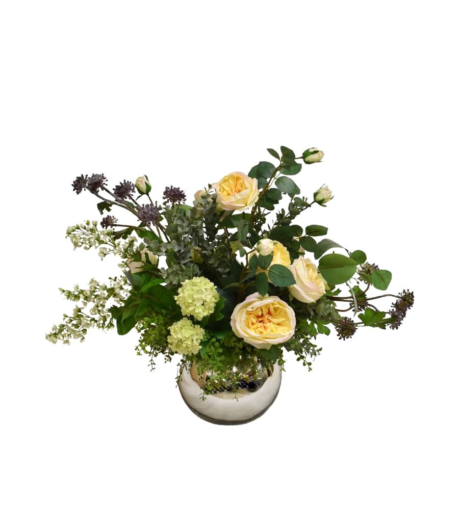 Centro de Mesa con Rosas en Tonos Amarillos y Follajes Artificiales en Base de Vidrio Tipo Espejo.