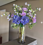 Arreglo Floral con Lisianthus e Hidrangeas y Follajes Artificiales en Florero de Vidrio