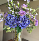 Arreglo Floral con Lisianthus e Hidrangeas y Follajes Artificiales en Florero de Vidrio