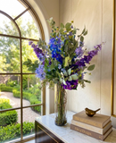 Arreglo Floral de Delphinium y Agaphantus y Follajes Artificiales en Cilindro de Vidrio