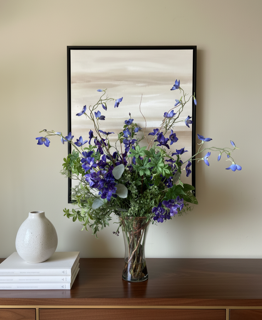Arreglo Floral con Delphinium Azul y Follajes Artificiales en Florero de Vidrio