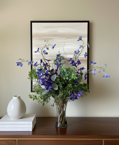 Arreglo Floral con Delphinium Azul y Follajes Artificiales en Florero de Vidrio