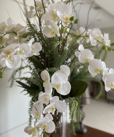 Orquideario con Phalaenopsis Blancas y Follajes Artificiales en Florero de Vidrio con Agua Acrílica