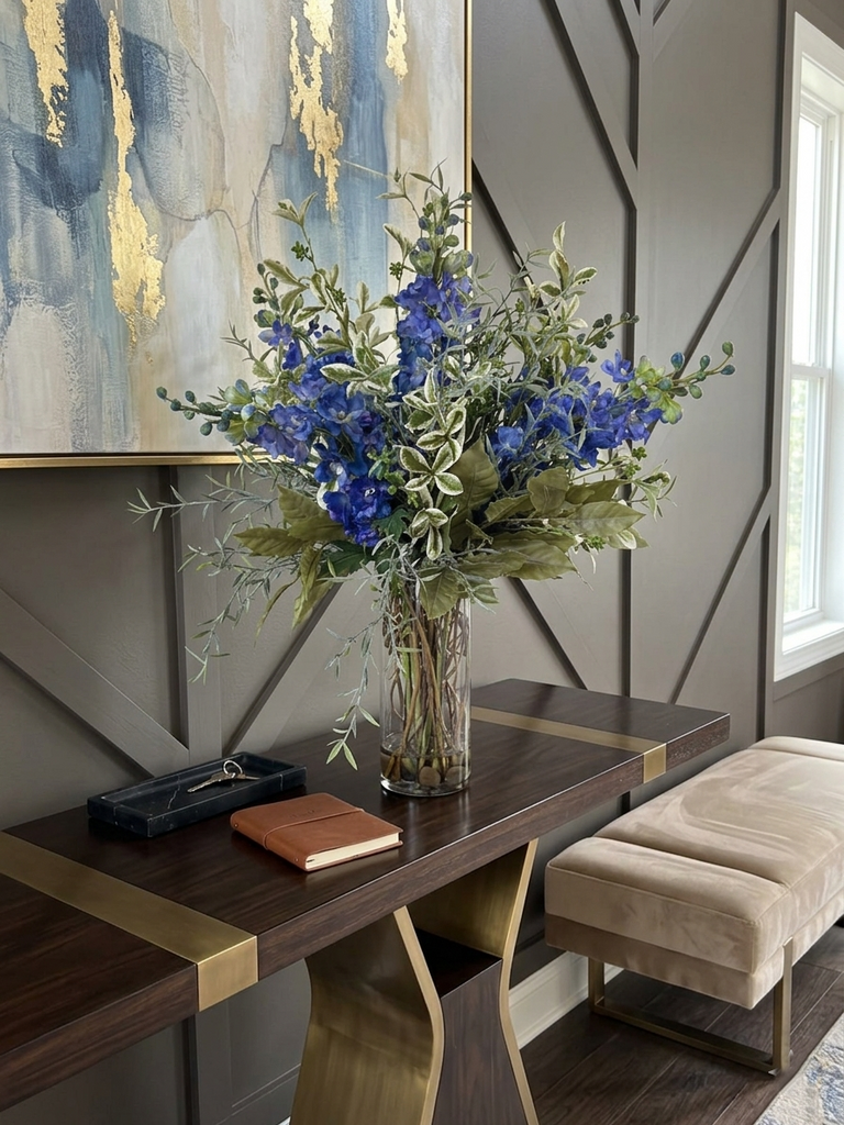 Arreglo Floral con Delphinium Azules y Follajes Artificiales en Florero de Vidrio