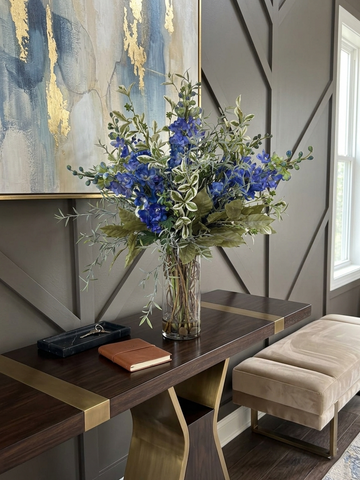 Arreglo Floral con Delphinium Azules y Follajes Artificiales en Florero de Vidrio