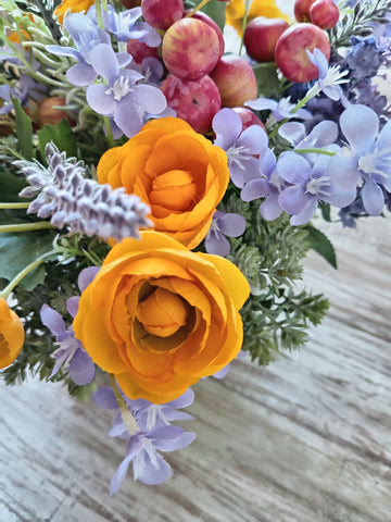 Arreglo Floral con Ranúnculus, Lavandas y Follajes Artificiales en Base Cuadrada de Vidrio y Agua Acrílica