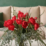 Arreglo Floral con Ranunculus Rojos y Follajes Artificiales en Base de Vidrio y Agua Acrílica