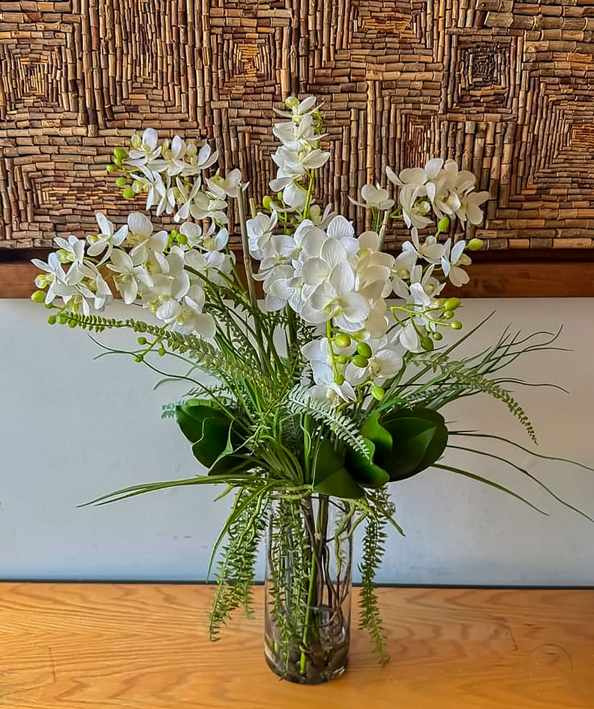 Orquideario con Mini Phalaenopsis Blancas y Follajes Artificiales en Florero de Vidrio con Agua Acrílica