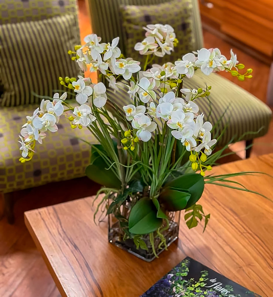 Orquideario con Mini Phalaenopsis y Follajes Artificiales en Florero Cuadrado de Vidrio con Agua Acrílica