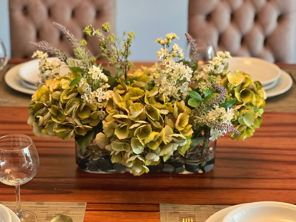 Arreglo Floral de Hydrangeas en Tonos Verdes y Follajes Artificiales en Base de Vidrio Rectangular con Agua Acrílica