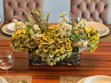 Arreglo Floral de Hydrangeas en Tonos Verdes y Follajes Artificiales en Base de Vidrio Rectangular con Agua Acrílica
