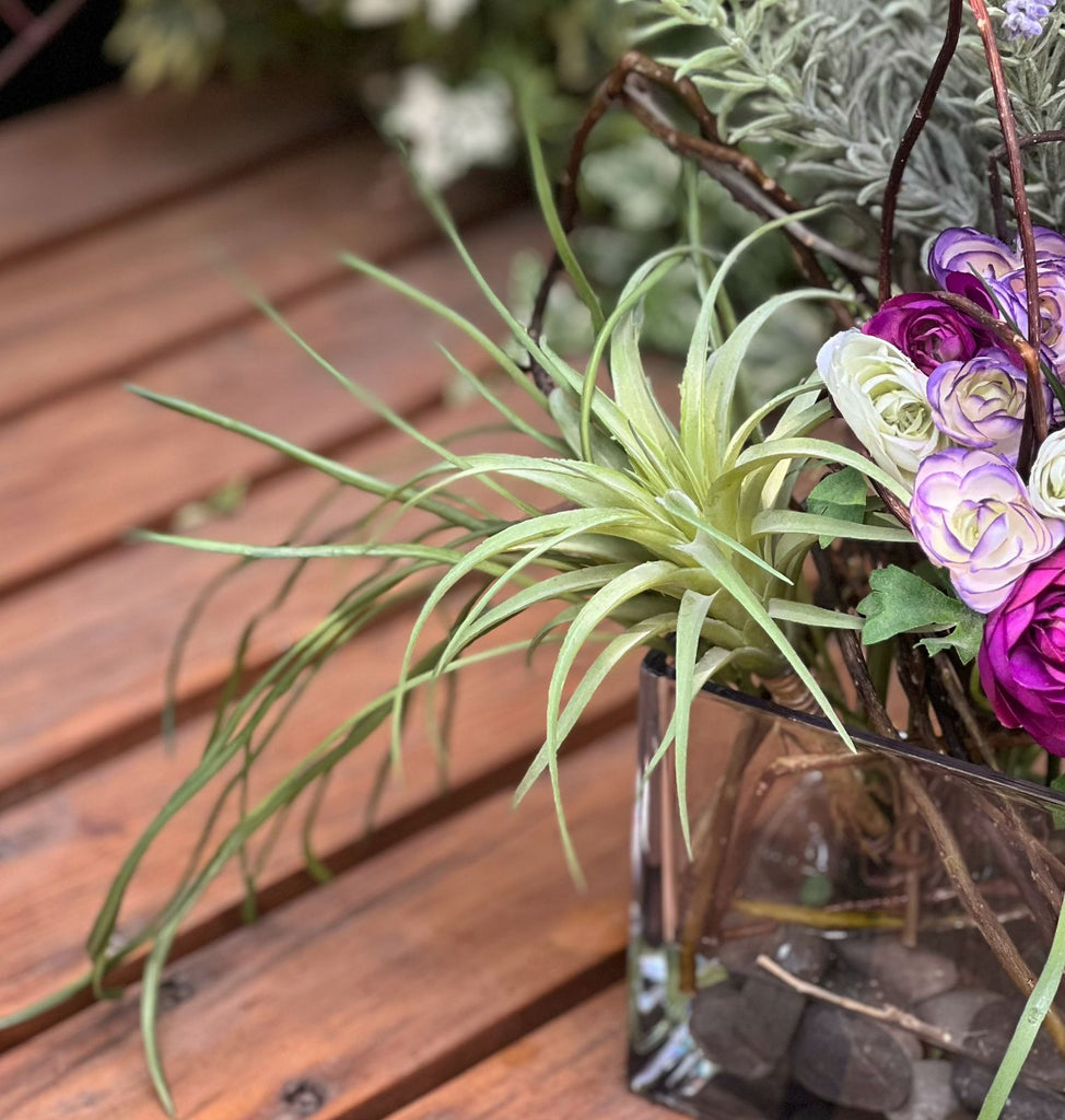 Arreglo Floral con Lavandas y Ranunculus Artificiales en Base Cuadrada de Vidrio y Agua Acrílica