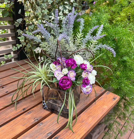 Arreglo Floral con Lavandas y Ranunculus Artificiales en Base Cuadrada de Vidrio y Agua Acrílica