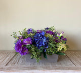 Centro de Mesa de Hidrangeas y Lisianthus con Follajes Artificiales en Base Cuadrada