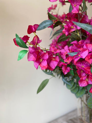 Arreglo Floral con Bougainvilleas y Follajes Artificiales en Florero de Vidrio