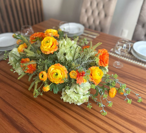 Centro de Mesa con Hidrangeas y Ranunculus Artificiales en Base Ovalada de Vidrio