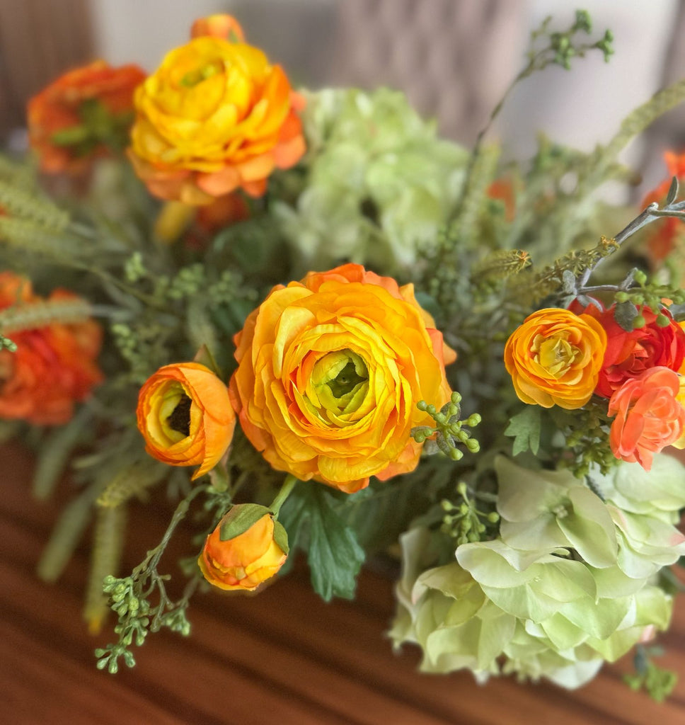 Centro de Mesa con Hidrangeas y Ranunculus Artificiales en Base Ovalada de Vidrio