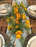 Centro de Mesa con Ranunculus y Follajes Artificiales en Base Ovalada de Vidrio