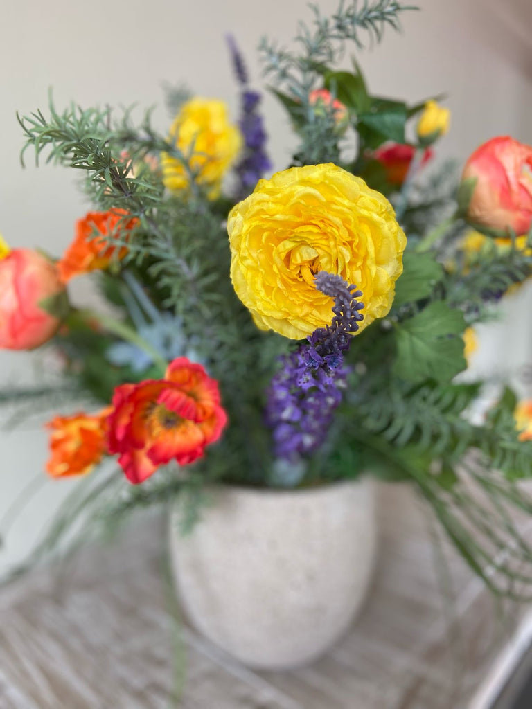Arreglo Floral con Ranunculus y Follajes Artificiales en Base Cantera