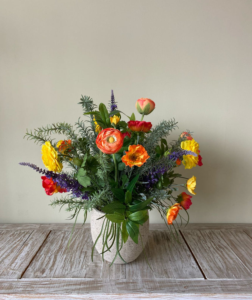 Arreglo Floral con Ranunculus y Follajes Artificiales en Base Cantera