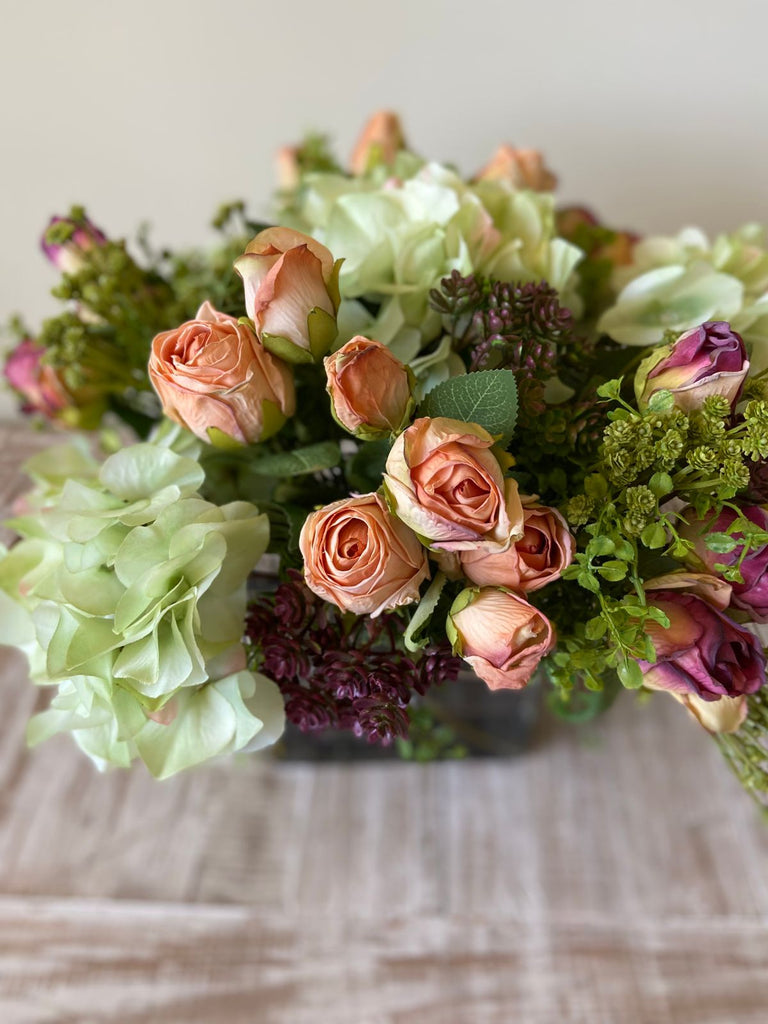 Arreglo Floral con Rosas e Hidrangeas con Follajes Artificiales en Base Cuadrada de Vidrio