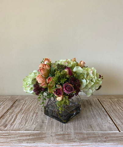 Arreglo Floral con Rosas e Hidrangeas con Follajes Artificiales en Base Cuadrada de Vidrio