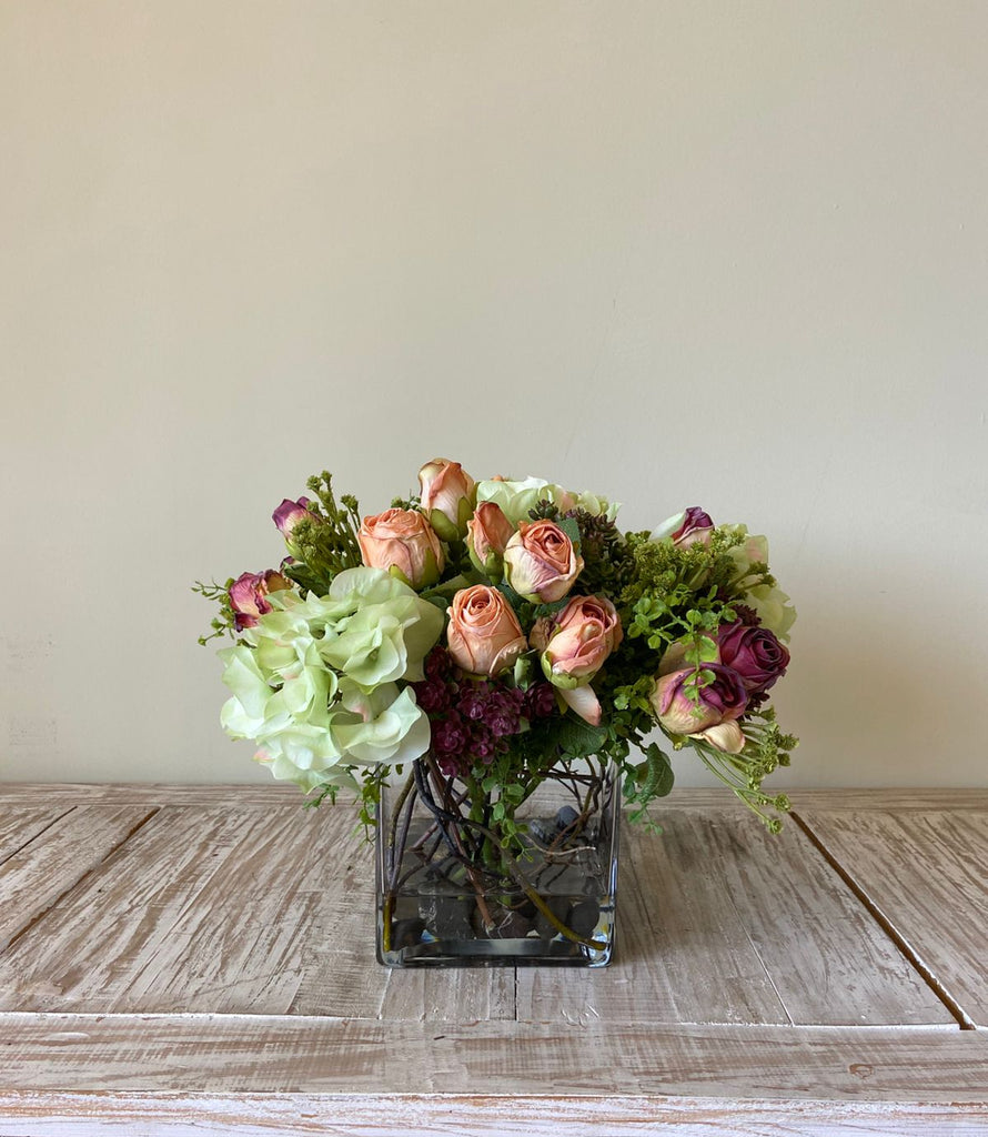 Arreglo Floral con Rosas e Hidrangeas con Follajes Artificiales en Base Cuadrada de Vidrio