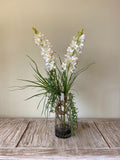Orquideario con Cymbidium con Follajes Artificiales en Florero de Vidrio