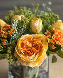 Arreglo Floral con Rosas Amarillas y Follajes Artificiales en Base Cuadrada de Vidrio