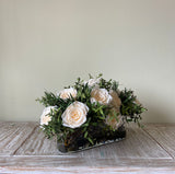Arreglo Floral con Rosas Preservadas Champagne en Base Ovalada de Vidrio con Agua Acrílica