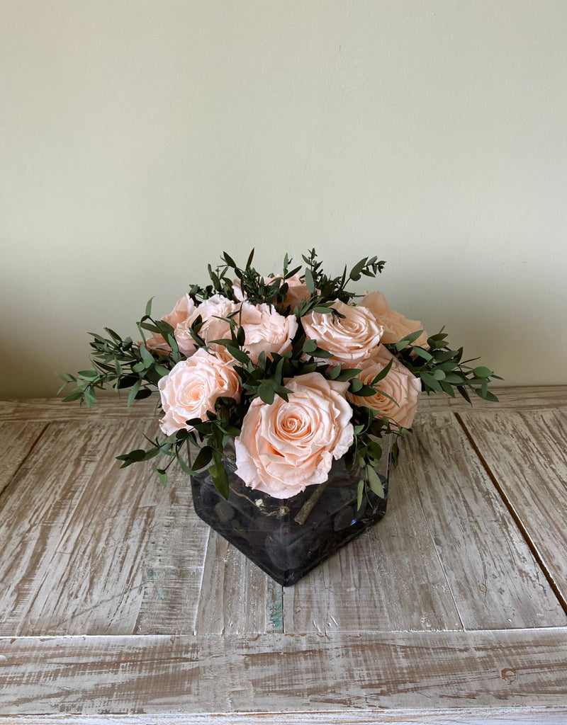 Arreglo Floral con Doce Rosas Preservadas Color Durazno Claro en Base Cuadrada de Vidrio con Agua Acrílica
