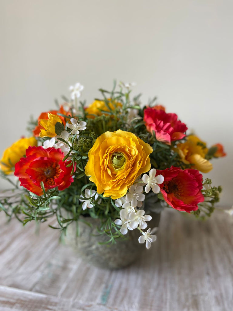 Centro de Mesa con Ranunculus y Follajes Artificiales en Base Tipo Cantera