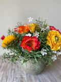 Centro de Mesa con Ranunculus y Follajes Artificiales en Base Tipo Cantera