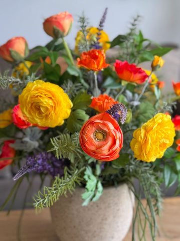 Arreglo Floral con Ranunculus y Follajes Artificiales en Base Cantera