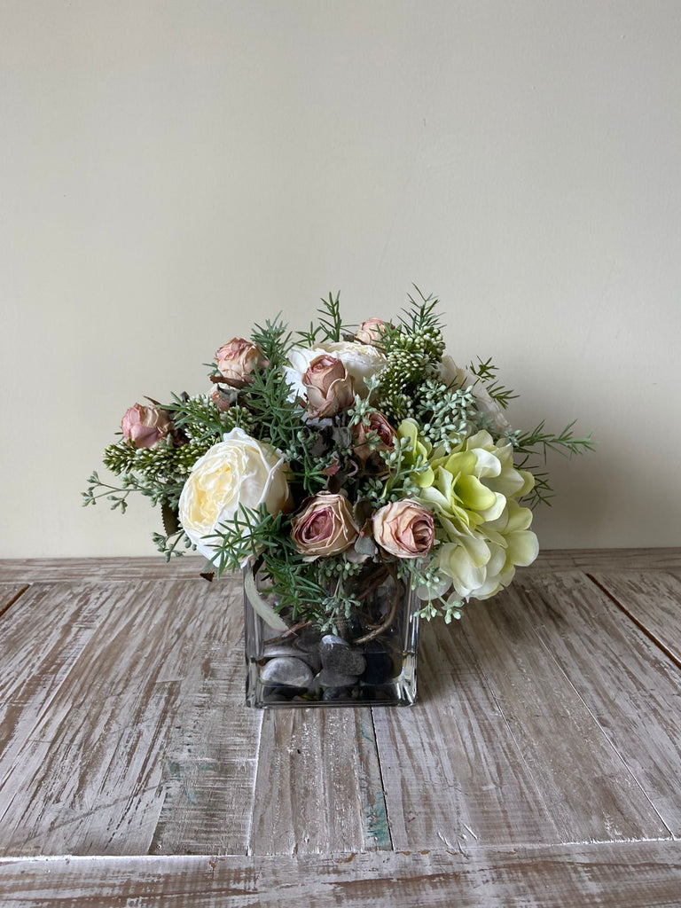 Arreglo Floral con Rosas e Hidrangeas con Follajes Artificiales en Base Cuadrada de Vidrio