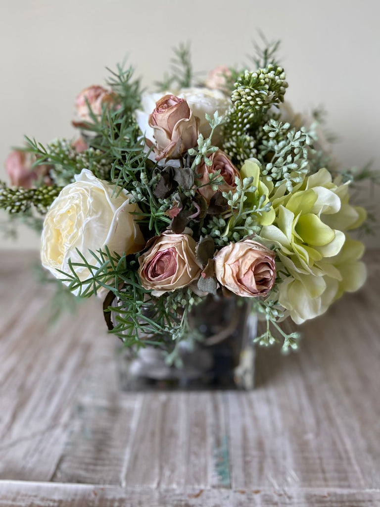 Arreglo Floral con Rosas e Hidrangeas con Follajes Artificiales en Base Cuadrada de Vidrio