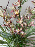Orquideario con Cymbidium y Follajes Artificiales en Florero de Vidrio