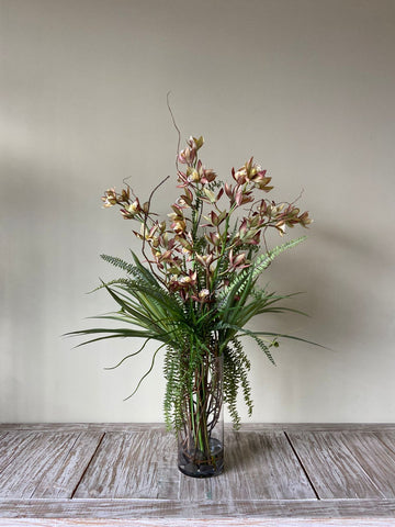 Orquideario con Cymbidium y Follajes Artificiales en Florero de Vidrio