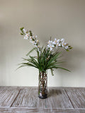 Orquideario con Dendrobium Blanca y Follajes Artificiales en Florero de Vidrio