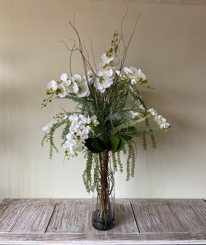 Orquideario con Phalaenopsis Blancas y Follajes Artificiales en Florero de Vidrio con Agua Acrílica