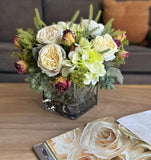 Arreglo Floral con Rosas e Hidrangeas con Follajes Artificiales en Base Cuadrada de Vidrio