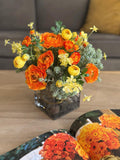 Arreglo Floral con Ranunculus y Follajes Artificiales en Base de Cuadrada con Agua Acrílica