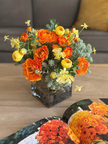 Arreglo Floral con Ranunculus y Follajes Artificiales en Base de Cuadrada con Agua Acrílica
