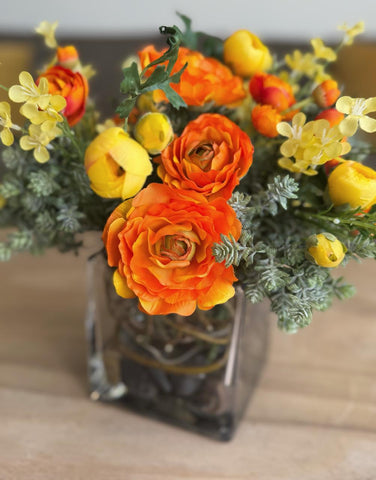 Arreglo Floral con Ranunculus y Follajes Artificiales en Base de Cuadrada con Agua Acrílica