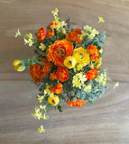 Arreglo Floral con Ranunculus y Follajes Artificiales en Base de Cuadrada con Agua Acrílica