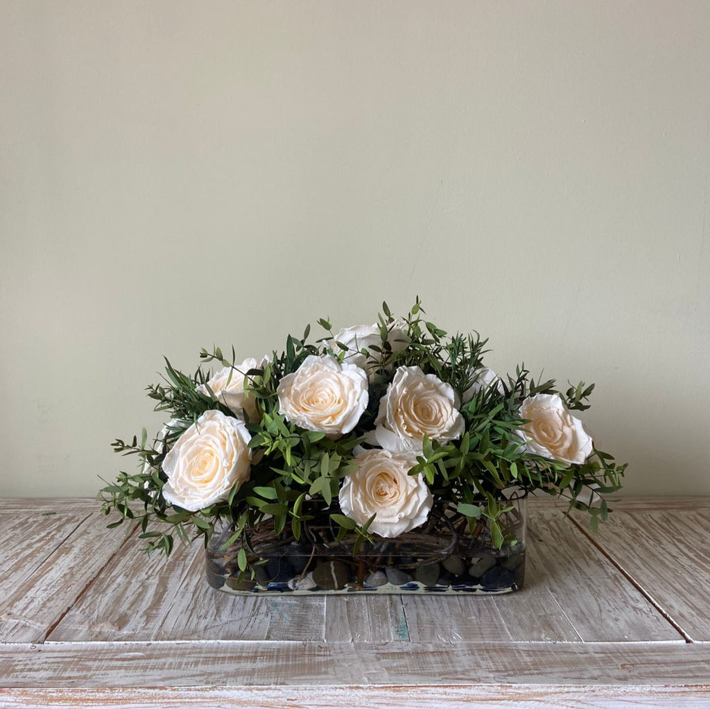 Arreglo Floral con Rosas Preservadas Champagne en Base Ovalada de Vidrio con Agua Acrílica