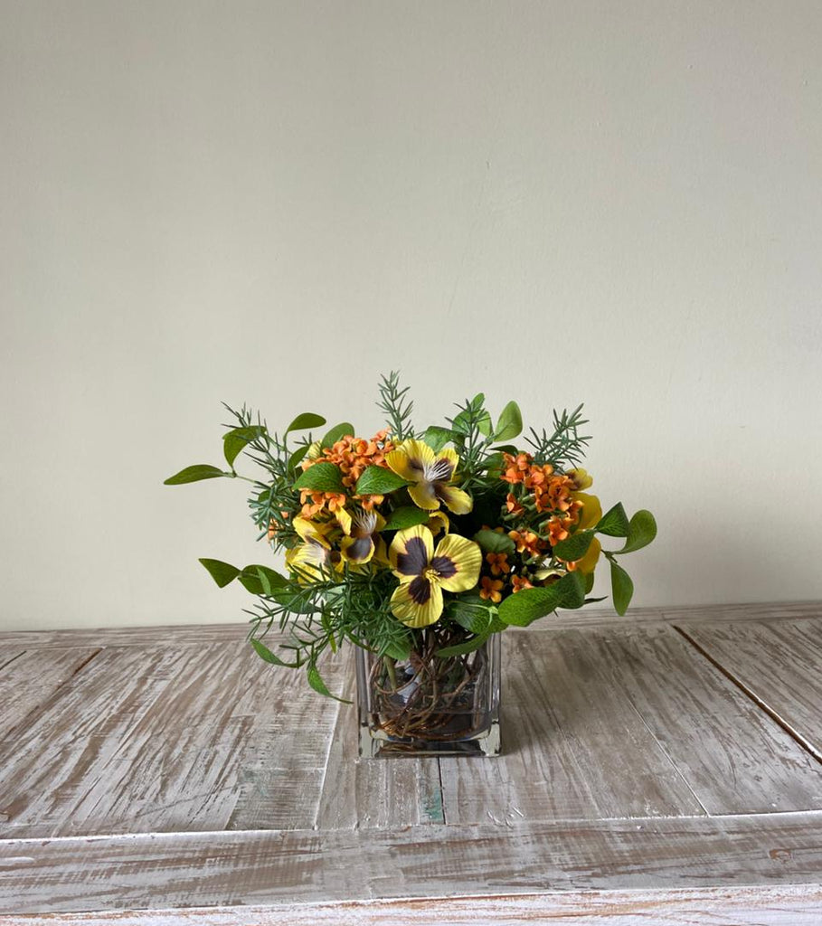 Arreglo Floral con Kalanchoe y Pansy Artificiales en Base Cuadrada de Vidrio