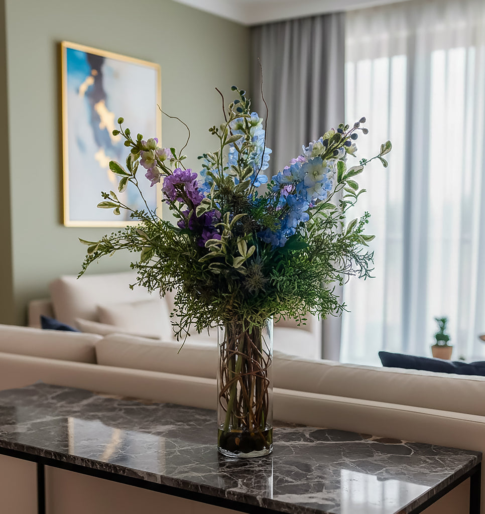 Arreglo Floral de Delphiniums con Follajes Artificiales en Florero de Vidrio - Martha Sophia